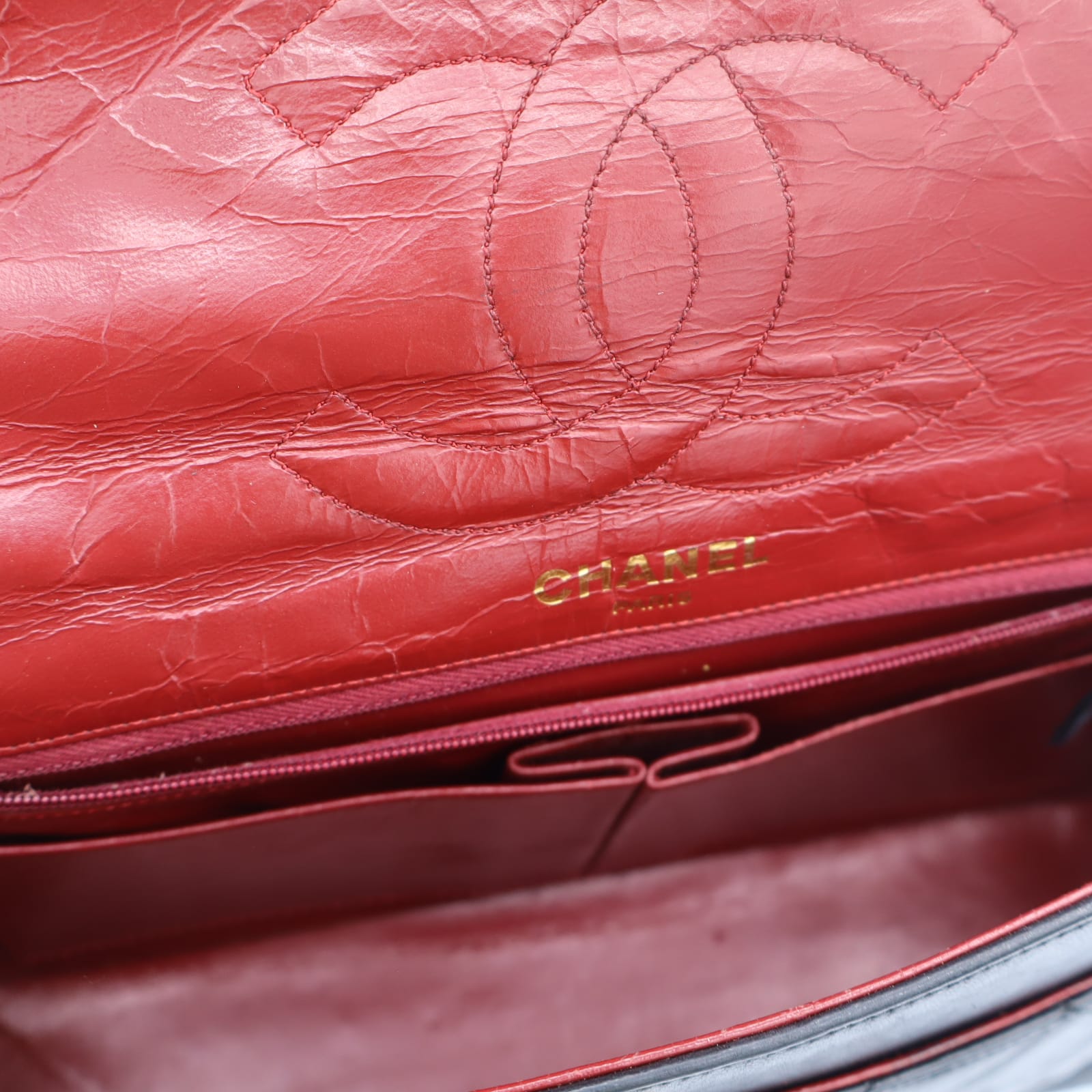 Intérieur du sac Chanel Double Rabat en cuir noir matelassé, doublure en cuir bordeaux et poche zippée