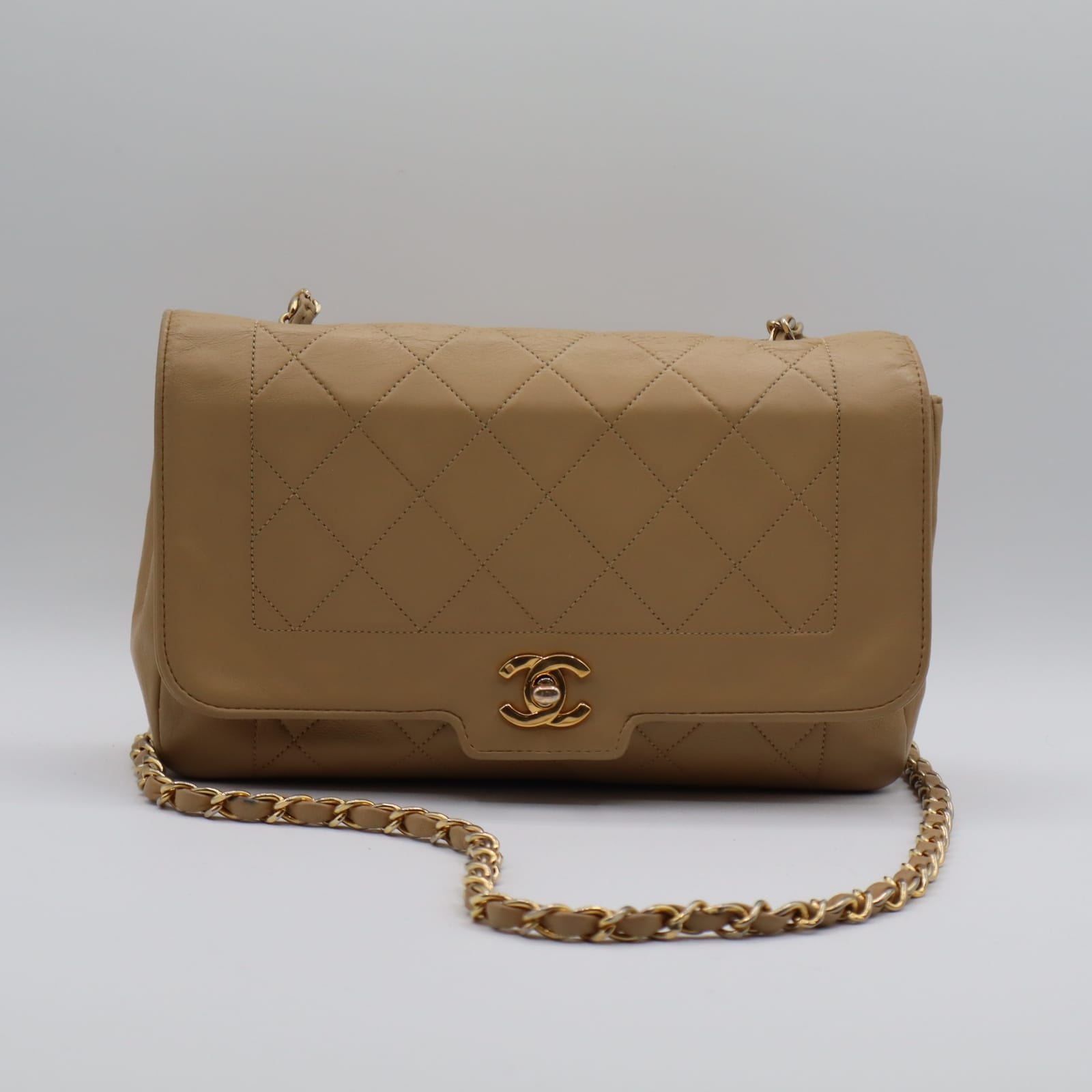 Sac Chanel Diana vintage en cuir beige vu de face, avec rabat matelassé et fermoir doré CC