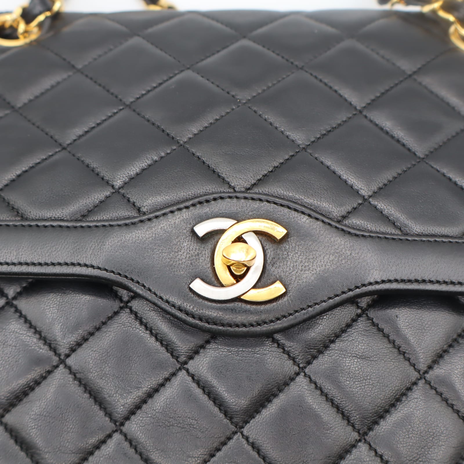 Fermoir CC doré du sac Chanel Double Rabat en cuir noir matelassé, gros plan
