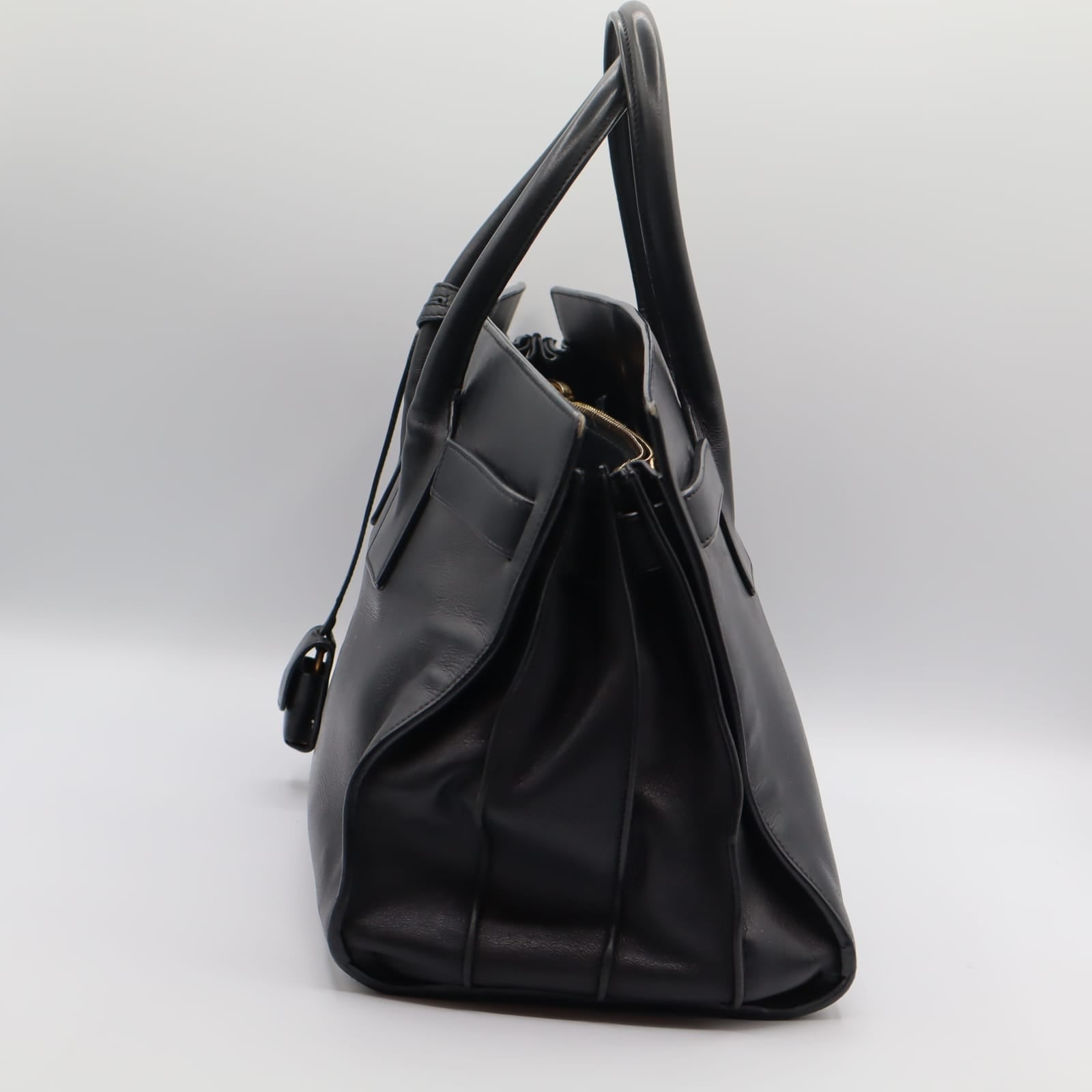 Vue latérale du Sac du Jour YSL noir, montrant l'épaisseur du sac et la structure souple.